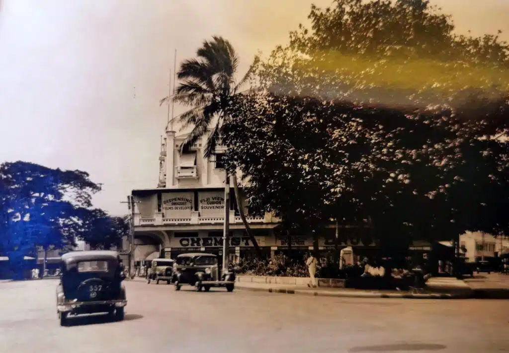 "Street scene in Suva, Fiji" 1935 photograph showing a slightly obstructed view of Michelmore Chemist, Boots' agent in Fiji (Fiji Museum P32.5/8).
